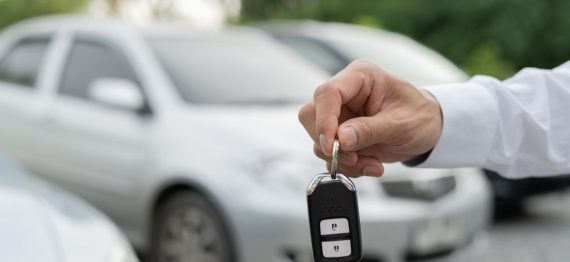 mans hand holding car keys