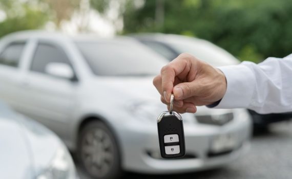 mans hand holding car keys